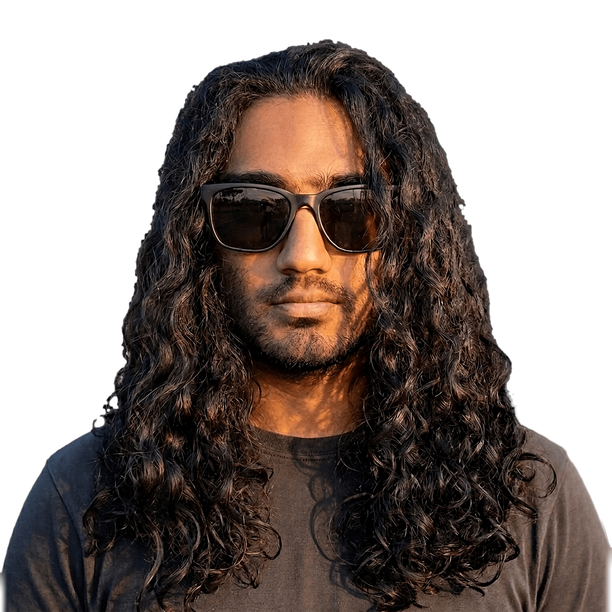A cutout portrait of Adit with long dark curly hair and sunglasses, lit by golden-hour sun.